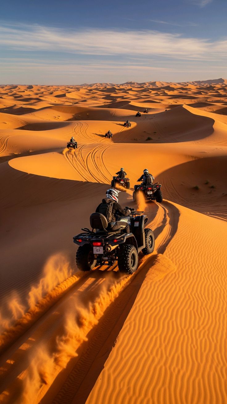 Quad wirbelt Sand auf einer Wüstenpiste auf