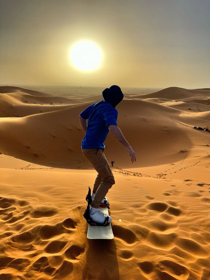 Sandboarder fährt eine Dünenflanke hinunter